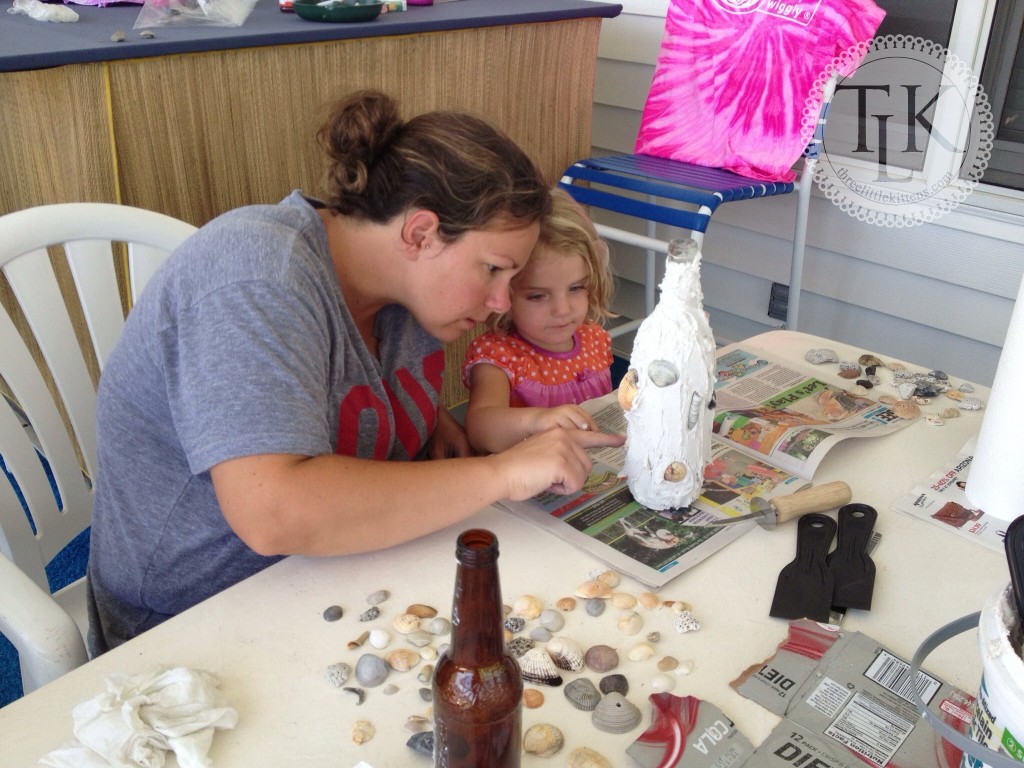 Denise and Ella working on a wine bottle